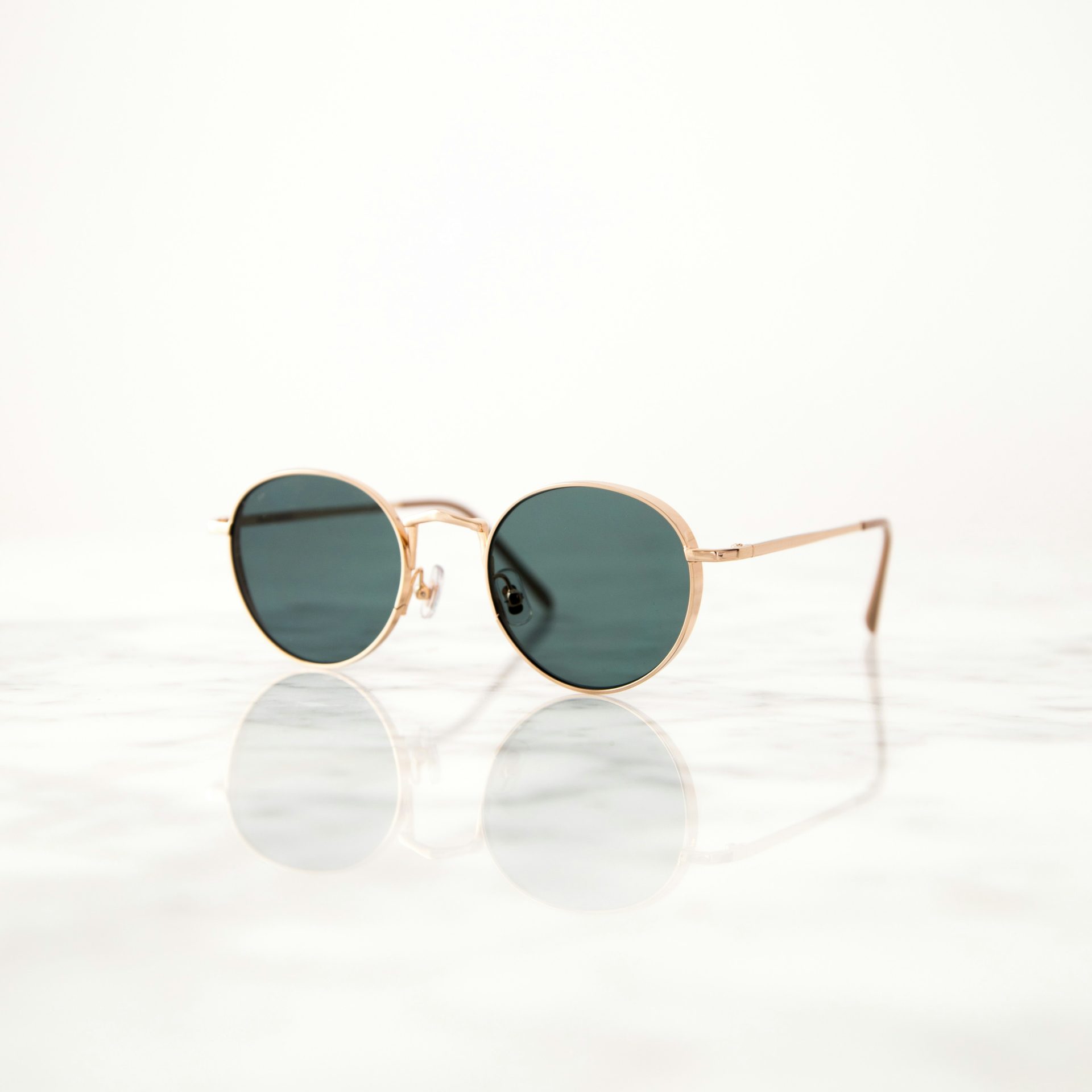 Round green sunglasses on marble